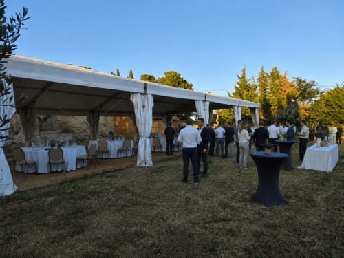 Installation d'événement en plein air au Domaine De Poulharies à Carcassonne avec tente blanche, tables et invités sur la pelouse