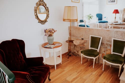 Elegante sala de estar na Casa de Campo da Quinta da Pegada em Óbidos com poltrona de veludo bordô, espelho ornamentado e décor de época