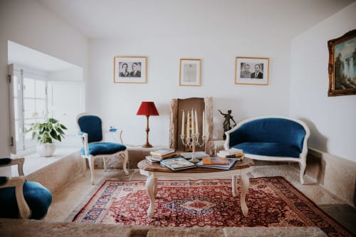 Elegante sala de estar na Casa de Campo da Quinta da Pegada em Óbidos com assentos em veludo azul, mesa de madeira e detalhes de época