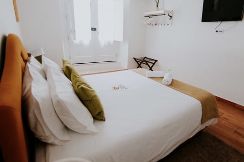 Quarto de luxo com cama de casal na Casa de Campo da Quinta da Pegada em Óbidos, com roupa de cama branca, vista para o jardim e comodidades modernas