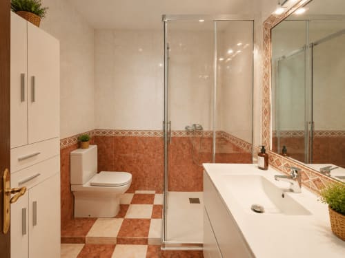Baño moderno en la casa rural Vila Santa Rita en Oia con piso de baldosas de terracota, ducha con cerramiento de cristal y lavamanos doble