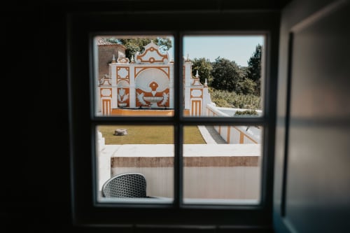 View from room window at Casa de Campo da Quinta da Pegada in Óbidos showing ornate garden sculpture and countryside