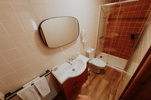 Modern bathroom in Casa de Campo da Quinta da Pegada, Óbidos with white sink, red vanity, toilet, and walk-in shower