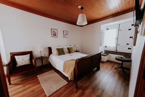 Spacious double bedroom at Casa de Campo da Quinta da Pegada in Óbidos with wooden ceiling, garden view, and modern amenities