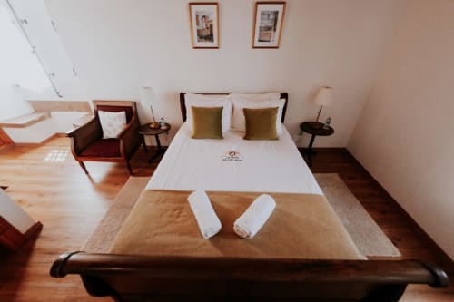 Spacious double bedroom at Casa de Campo da Quinta da Pegada in Óbidos with garden view, wooden floors, and modern amenities