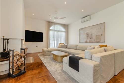 Sala moderna en Ayma Villa Vista al Valle con sofá seccional, chimenea, TV montada en pared y vistas a las montañas