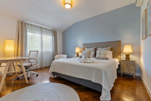 Amplia habitación de villa con pared azul, escritorio de madera, vistas a la montaña y comodidades modernas