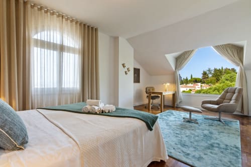 Espacioso dormitorio de villa con vistas a la montaña, cama, zona de estar, escritorio y acceso a terraza en Alhaurín de la Torre