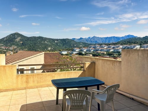 Terrasse vue montagne avec table à manger au Studio Sémaphore à L'Île-Rousse, Corse, surplombant le village et les pics