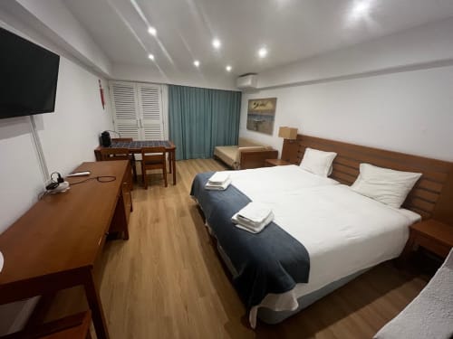 Apartamento estúdio moderno no Algarve Golden com cama de casal, escrivaninha, TV, piso de madeira e móveis contemporâneos em
