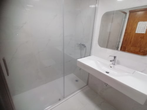 Banheiro moderno com duche integrado, lavatório branco e espelho no apartamento Algarve Golden em Cabanas de Tavira
