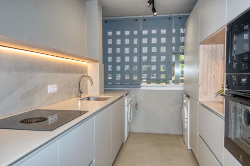 Cuisine moderne de l'hôtel Finques Garcia Enrich à Palafrugell avec meubles blancs, électroménagers inox et vue sur la ville