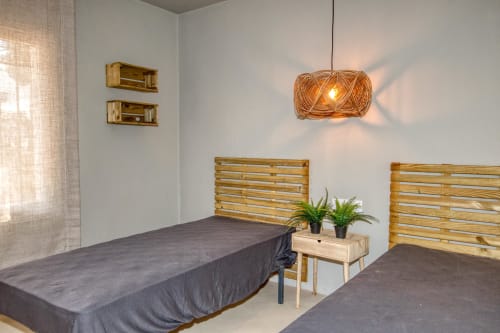 Salle de soin moderne chez Finques Garcia Enrich à Palafrugell avec lits de massage, lampe suspendue tissée et plantes en pots