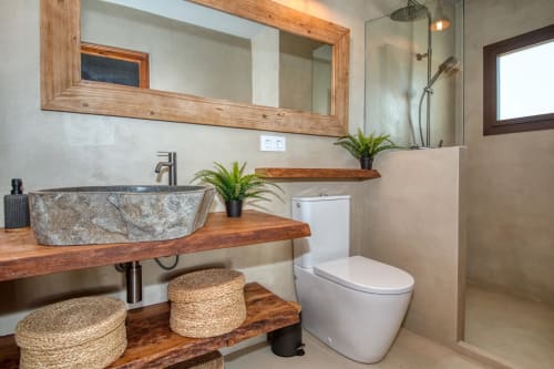 Salle de bain moderne à Finques Garcia Enrich, Palafrugell avec lavabo en pierre, meuble vasque en bois et douche à l'italienne