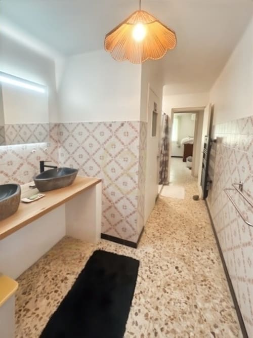 Couloir de salle de bain moderne à l'appartement Calvi avec carrelage à motifs, sol béton, vasques et coquillages