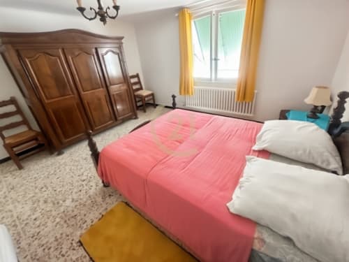 Chambre spacieuse Century 21 Dary à L'Île-Rousse avec literie rose, armoire en bois et vue sur jardin