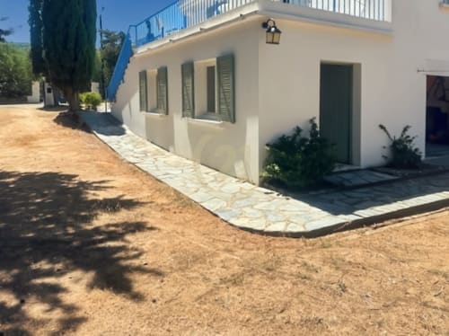 Authentique maison de Calvi avec vue sur jardin, façade blanche, chemin de pierre, volets verts, cyprès, propriété de L'Île-Rousse