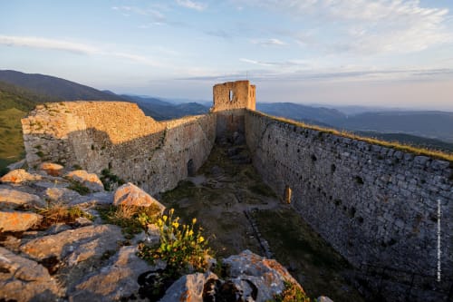 Ruines de forteresse médiévale en pierre au coucher de soleil près de Ferrières-sur-Ariège, avec vue sur la vallée montagnarde