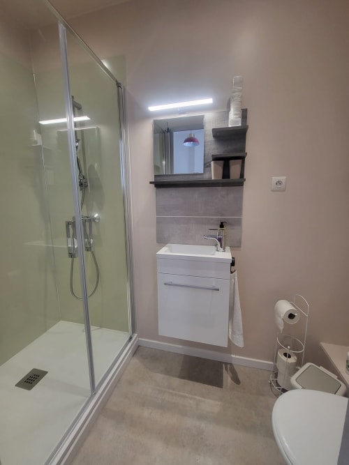 Salle de bain moderne avec douche, vasque blanche et toilettes à Comme à la maison B&B, chambre Puilaurens, Espéraza