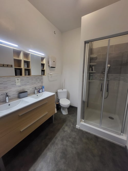 Salle de bain moderne de la chambre Montségur à Comme à la maison B&B à Espéraza avec double vasque, toilettes et douche à l'italienne