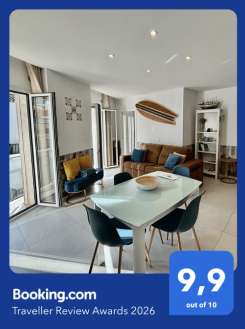 Salon moderne de Casa na Onda à Nazaré avec table à manger blanche, canapé marron, accents bleus et vue sur l'océan