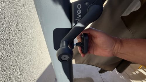 Personne tenant un stabilisateur gimbal Viveo noir sur la terrasse de l'hôtel Bonifacio