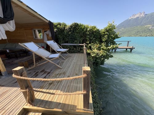 Terrasse en bois en bord de lac avec chaises longues au gîte de Chaparon, Lathuile, face au lac alpin turquoise