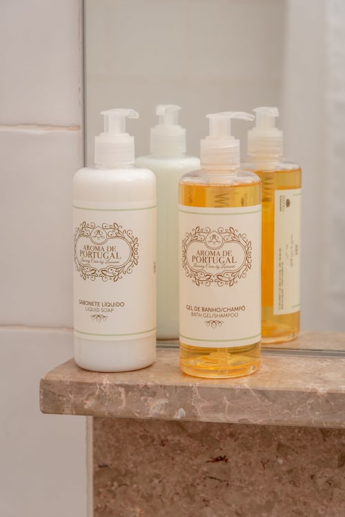 Produtos de banho Aroma de Portugal exibidos em prateleira de mármore na boutique hotel Monte das Açoteias em Tavira