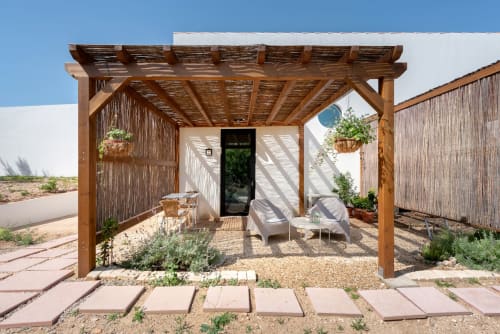 Pérgola de madeira com espreguiçadeiras no pátio da pousada Monte das Açoteias em Tavira, Portugal