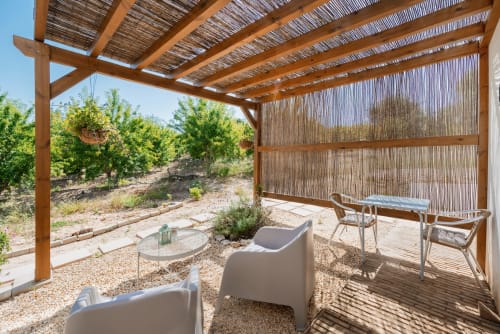 Pérgola sombreada com espreguiçadeiras com vista para o jardim do hotel rural Monte das Açoteias em Tavira, Portugal