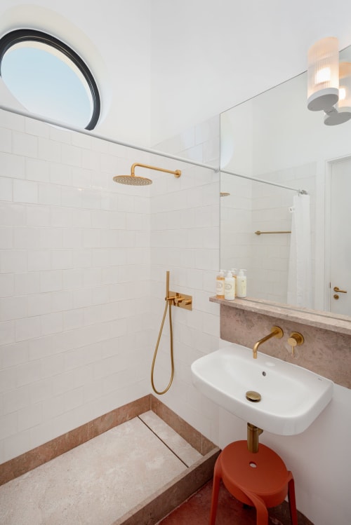 Banheiro moderno com azulejos brancos estilo metrô, torneiras em latão e chuveiro aquecido no quarto da pousada Monte das Açoteias