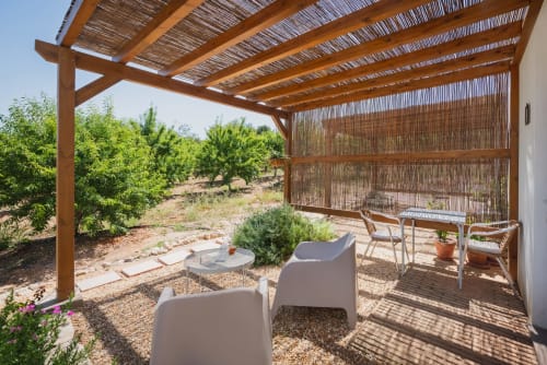 Área de estar com pérgola coberta em Monte das Açoteias com vistas para o jardim, Tavira Portugal