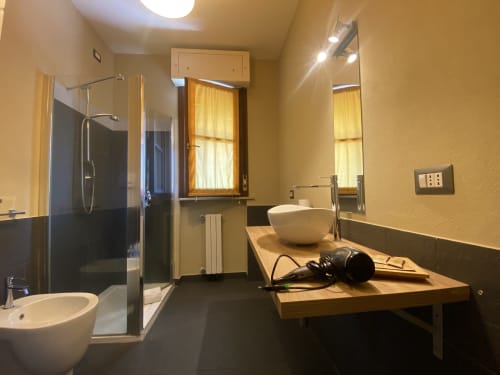 Modern bathroom in Cinelli Apartment, Vercelli with vessel sink, walk-in shower, and contemporary fixtures