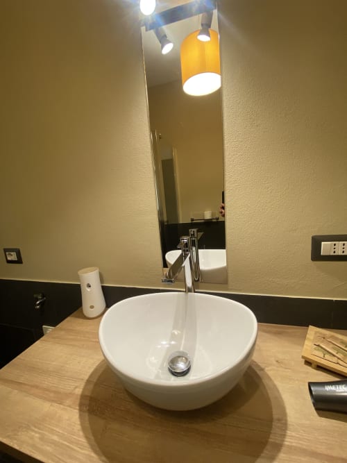 Modern bathroom sink with white vessel bowl and chrome faucet at Cinelli Apartment in Vercelli, Italy