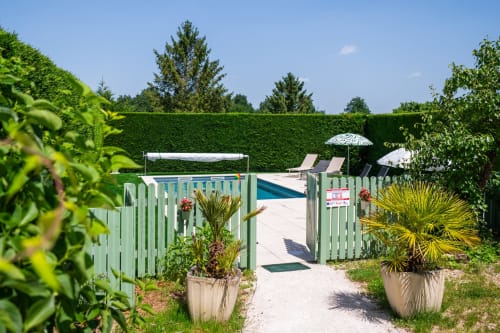 Espace piscine de La Maison Du Saule B&B à Faverolles sur Cher avec portail vert, transats et jardins aménagés