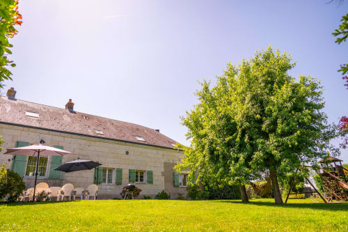 La Maison Du Saule : maison en pierre, pelouse impeccable, parasols et grands arbres à Faverolles sur Cher