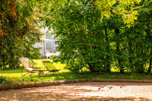 Jardin paisible de La Maison Du Saule avec chaises longues sous les arbres feuillu à Faverolles sur Cher