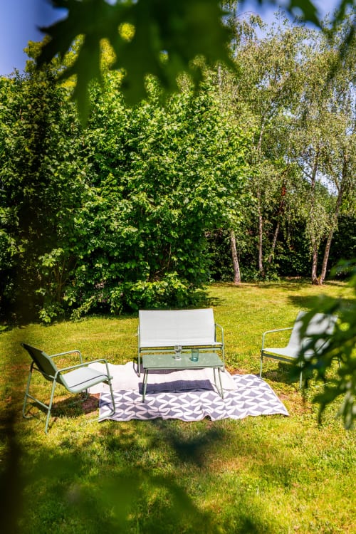 Espace de détente extérieur à La Maison Du Saule B&B avec chaises longues et banc sur tapis à motifs