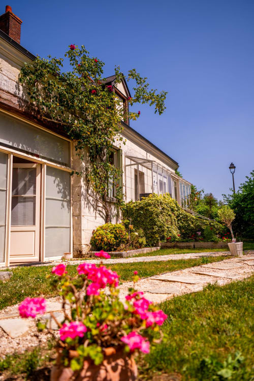 Façade de La Maison Du Saule B&B avec fleurs roses en fleur et murs couverts de lierre à Faverolles sur Cher, France