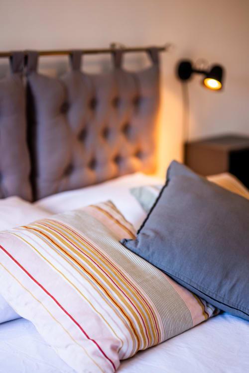Chambre accueillante de La Maison Du Saule B&B à Faverolles sur Cher, avec literie rayée et lampe de chevet chaleureuse