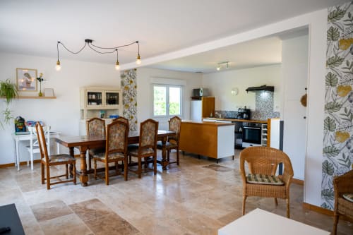 Salle à manger et cuisine du gîte Petit Saule à La Maison Du Saule avec chaises en bois, cuisine équipée et vue sur le jardin