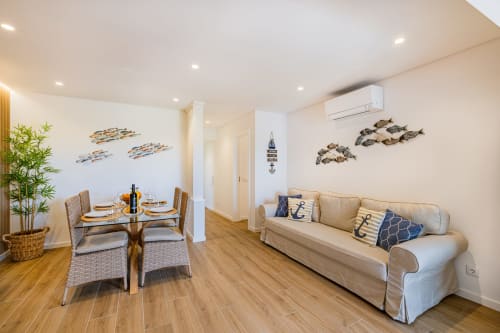 Apartamento Atlantic Places em Albufeira com sala de estar temática costeira, área de refeições e vista para o jardim