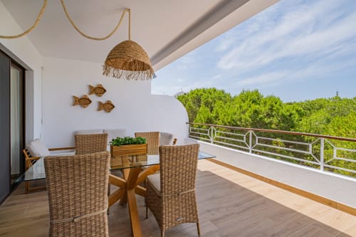 Varanda do apartamento Salgados Hideaway em Atlantic Places Albufeira com mobiliário de vime e vistas para o jardim