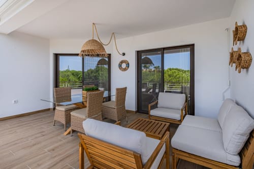 Terraço moderno do apartamento em Atlantic Places Albufeira com mobiliário em vime, área de refeições e vistas para o jardim