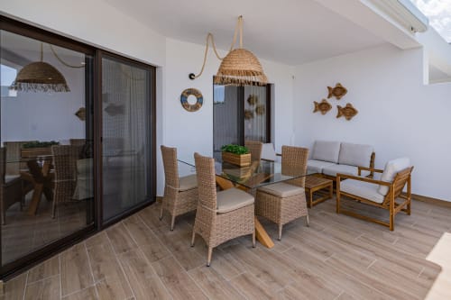 Pátio moderno no Atlantic Places Albufeira com luminárias suspensas de rattan, cadeiras de jantar em vime, área de estar em madeira e