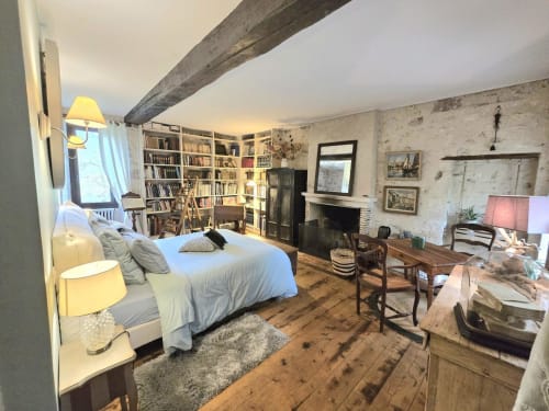 Chambre de l'Érudit aux 2 Brigards : chambre avec poutres apparentes, cheminée, bibliothèque et plancher en bois