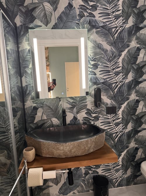 Bagno moderno presso Zappy Domus con lavabo in pietra nera, specchio illuminato, carta da parati botanica e rubinetteria nera nella stanza Zen