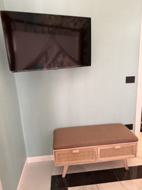 Camera moderna di Zappy Domus con TV a parete e panchetta in legno con cuscino marrone