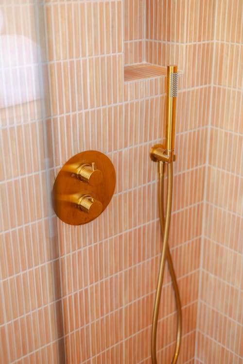 Robinetterie dorée avec mitigeur thermostatique sur mur en carrelage terre cuite à L'Ode à Pierre B&B, Dax