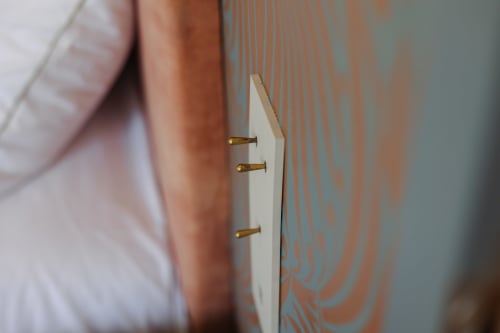 Détail de mur orné avec clous en laiton à L'Ode à Pierre, Dax